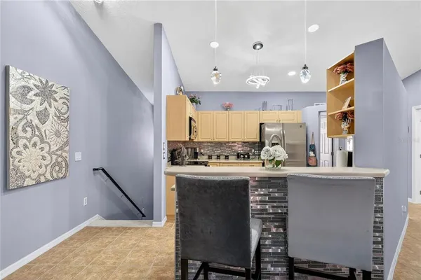 a kitchen with kitchen island a stove a table and chairs in it