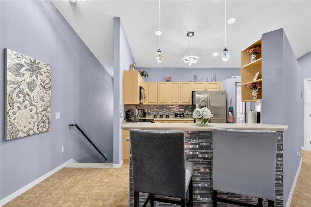 5336 Edgewater Way Oxford, FL 34484 - Photo 10 of 45 a kitchen with kitchen island a stove a table and chairs in it