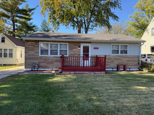 a view of a house with a yard and sitting area