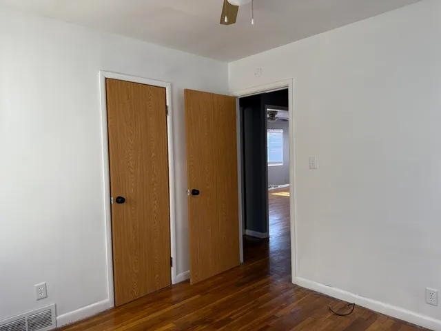 a view of empty room with wooden floor