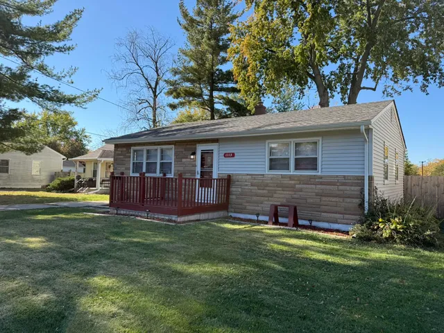 a view of a house with a yard and sitting area