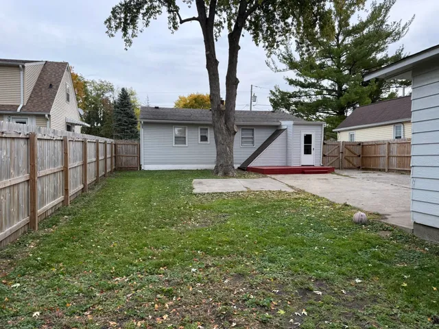 a view of yard with small cabin and wooden fence