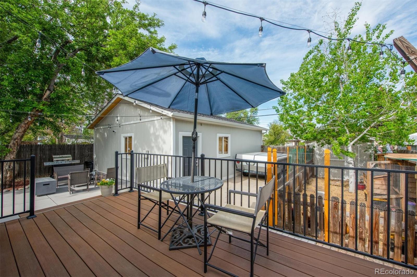 4335 Zenobia Street Denver, CO 80212 - Photo 15 of 26 a view of a roof deck with table and chairs under an umbrella with wooden floor