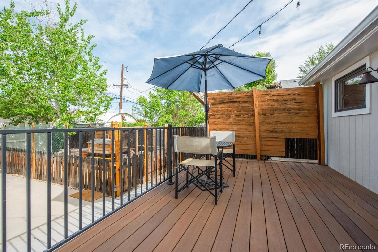 4335 Zenobia Street Denver, CO 80212 - Photo 16 of 26 a view of deck with table and chairs under an umbrella with wooden floor