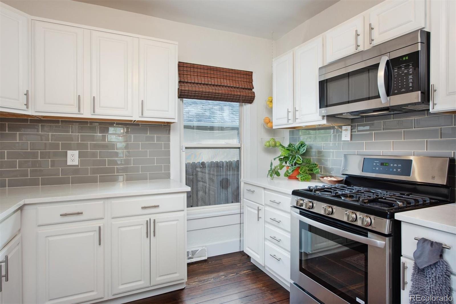4335 Zenobia Street Denver, CO 80212 - Photo 8 of 26 a kitchen with stainless steel appliances granite countertop white cabinets and a stove top oven