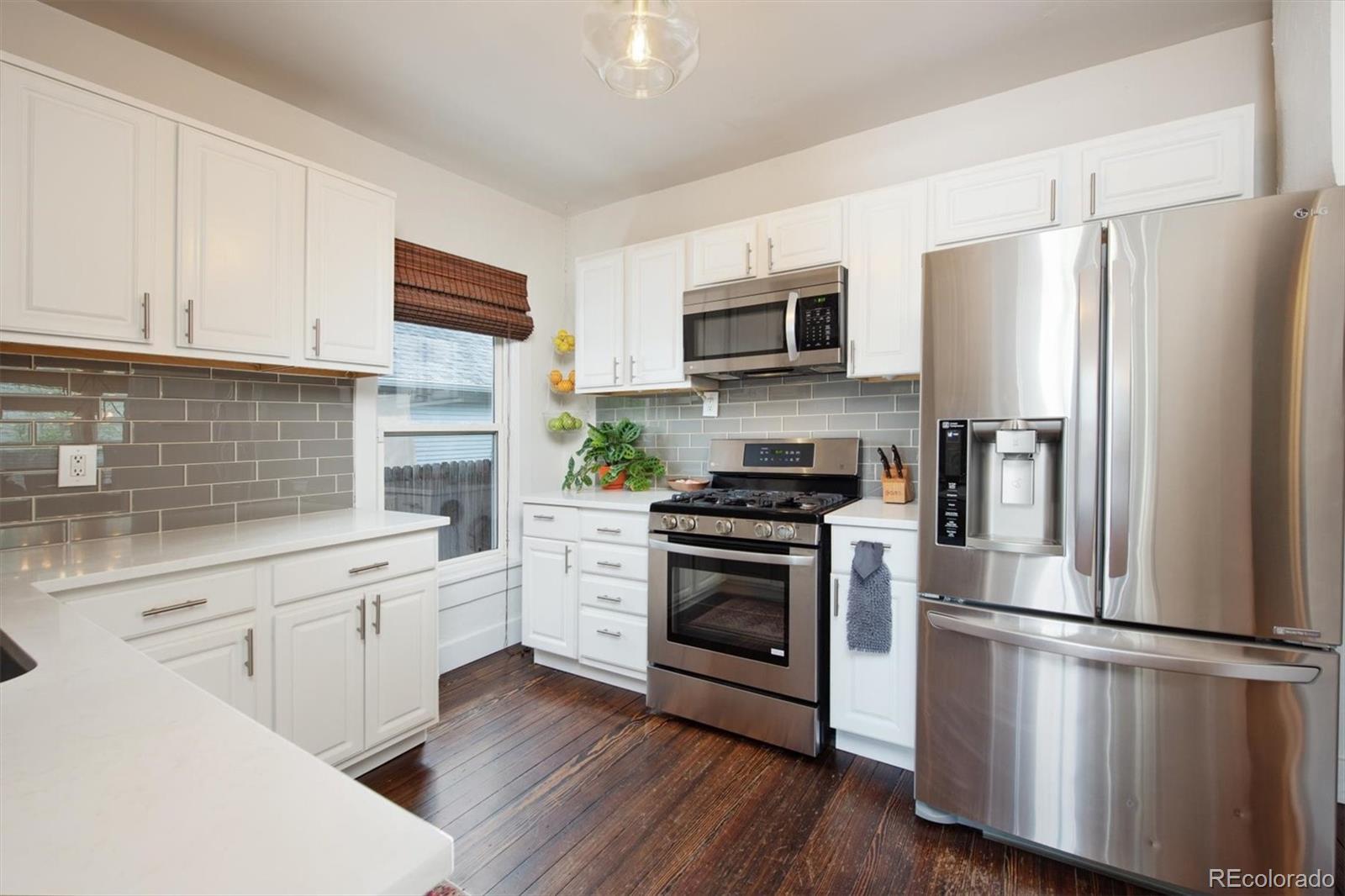 4335 Zenobia Street Denver, CO 80212 - Photo 9 of 26 a kitchen with stainless steel appliances a refrigerator stove and microwave