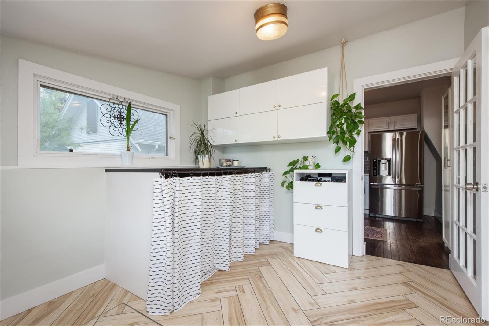 4335 Zenobia Street Denver, CO 80212 - Photo 10 of 26 a kitchen with a refrigerator and white cabinets