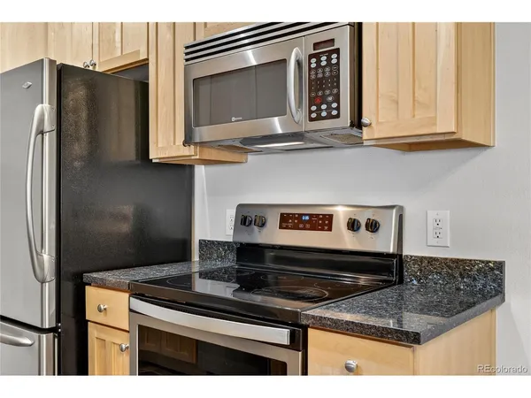 a kitchen with stainless steel appliances granite countertop a stove microwave and refrigerator
