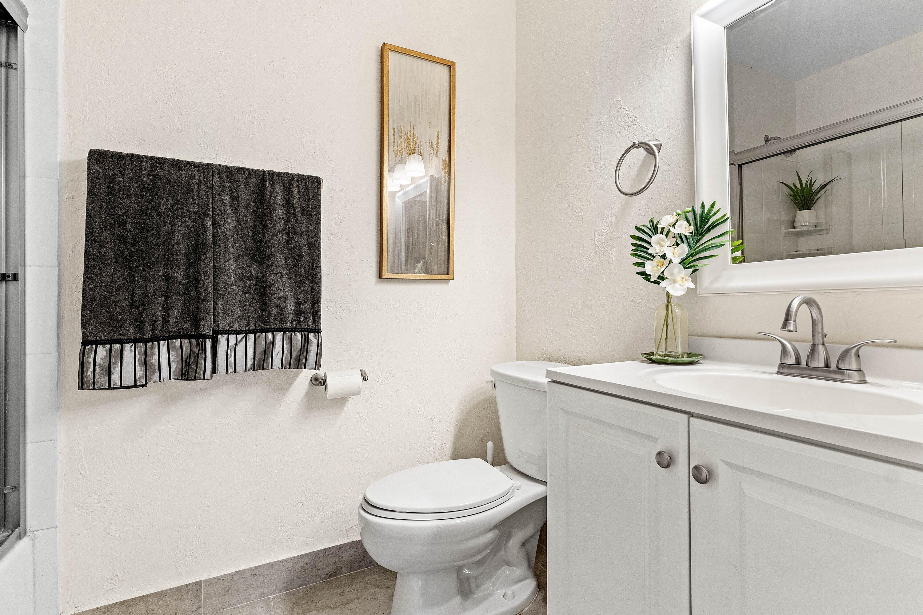13899 Via Aurora, Unit C Delray Beach, FL 33484 - Photo 26 of 39 a bathroom with a toilet a sink and mirror