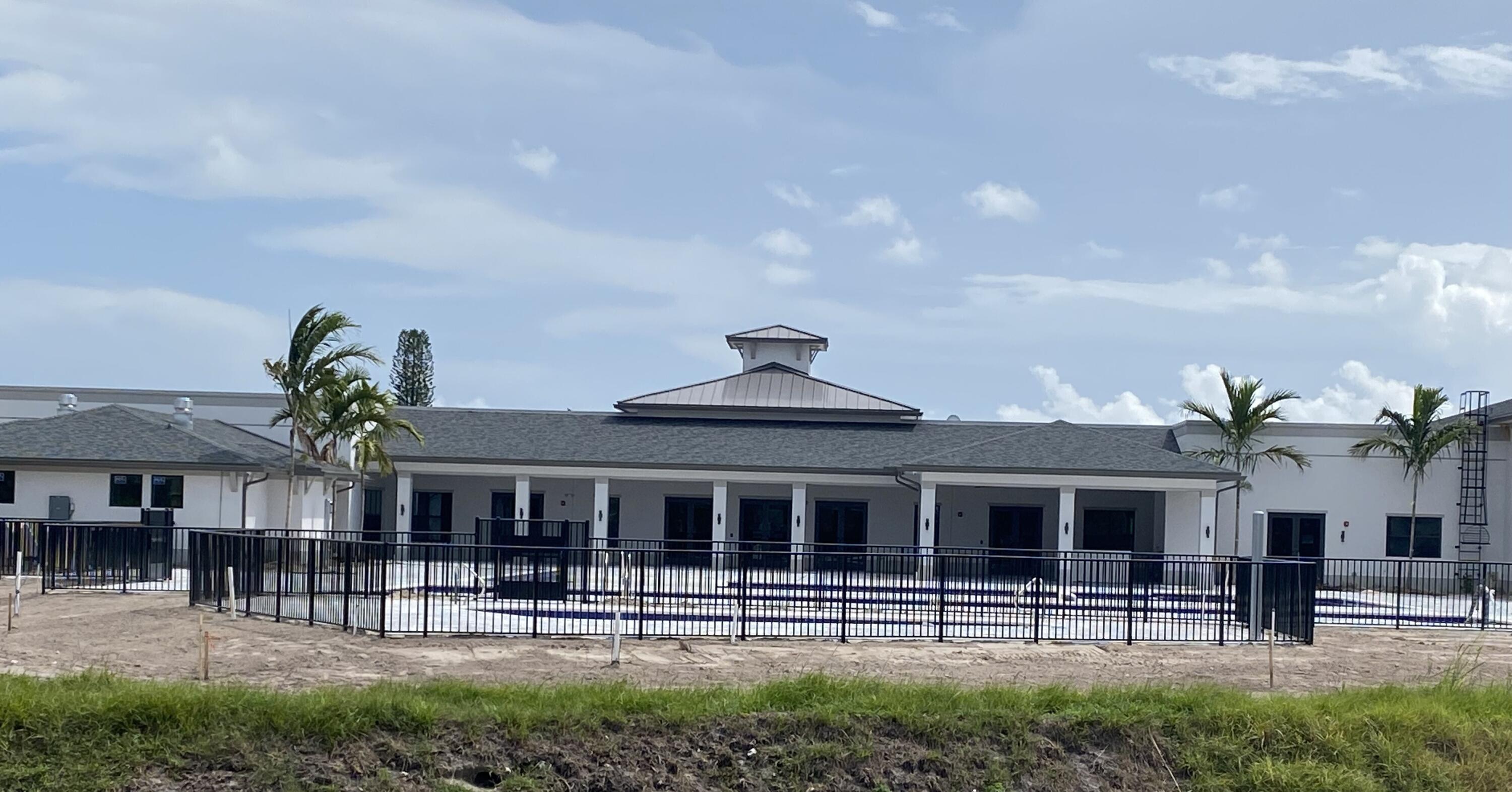 13899 Via Aurora, Unit C Delray Beach, FL 33484 - Photo 35 of 39 a front view of a house with garden