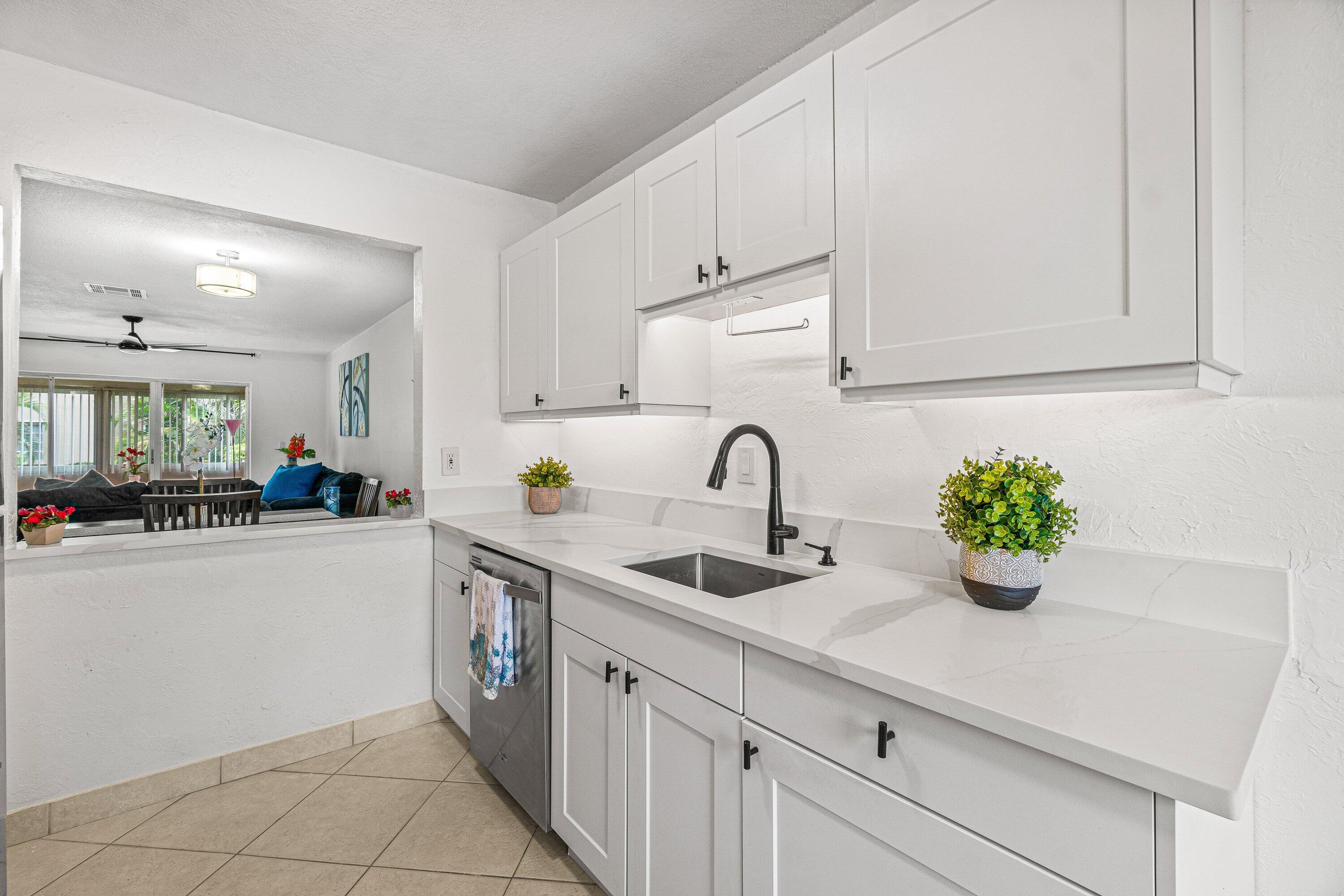13899 Via Aurora, Unit C Delray Beach, FL 33484 - Photo 4 of 39 a kitchen with a sink white cabinets and window