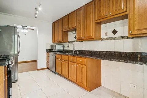 a kitchen with granite countertop a sink a stove and cabinets