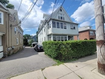 230 Corey Road Boston, MA 02135 - Photo 2 of 13 a view of a brick house with a yard and plants