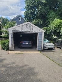 230 Corey Road Boston, MA 02135 - Photo 9 of 13 a front view of a house with a yard and garage