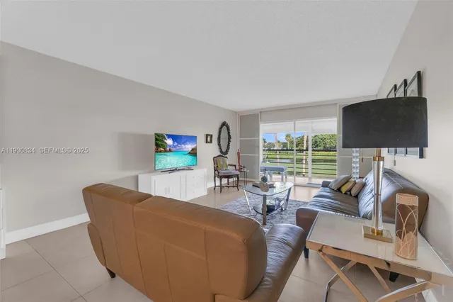 a living room with furniture a flat screen tv and a large window