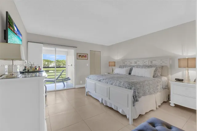 a bedroom with a bed lamp and a large window