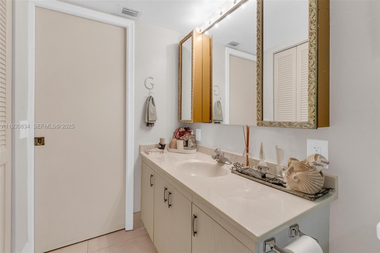4402 Martinique Court, Unit K2 Coconut Creek, FL 33066 - Photo 26 of 38 a bathroom with a sink and a mirror