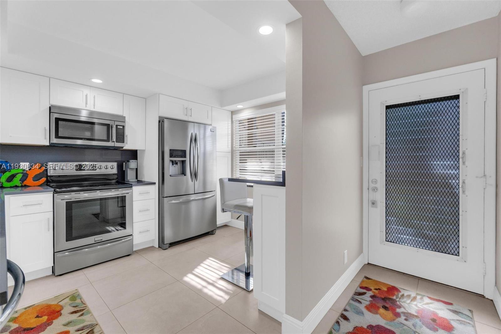 4402 Martinique Court, Unit K2 Coconut Creek, FL 33066 - Photo 3 of 38 a kitchen with stainless steel appliances a stove a microwave and a refrigerator