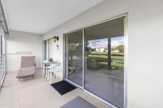 a balcony with chairs and view of living room