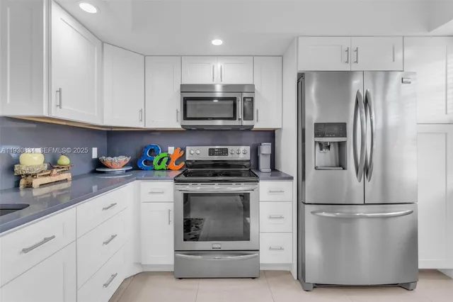 a kitchen with cabinets stainless steel appliances and a counter space