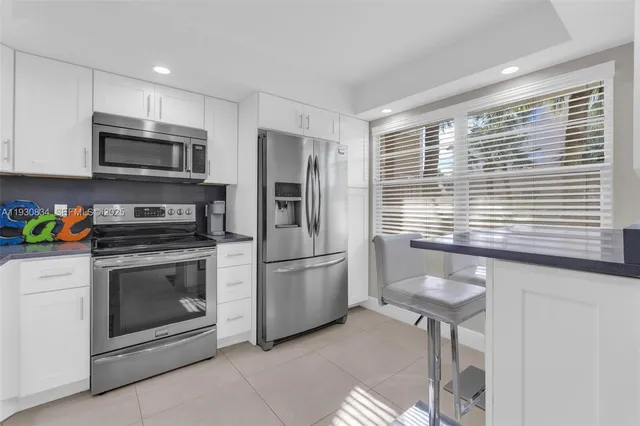 a kitchen with stainless steel appliances granite countertop a stove a microwave and a refrigerator