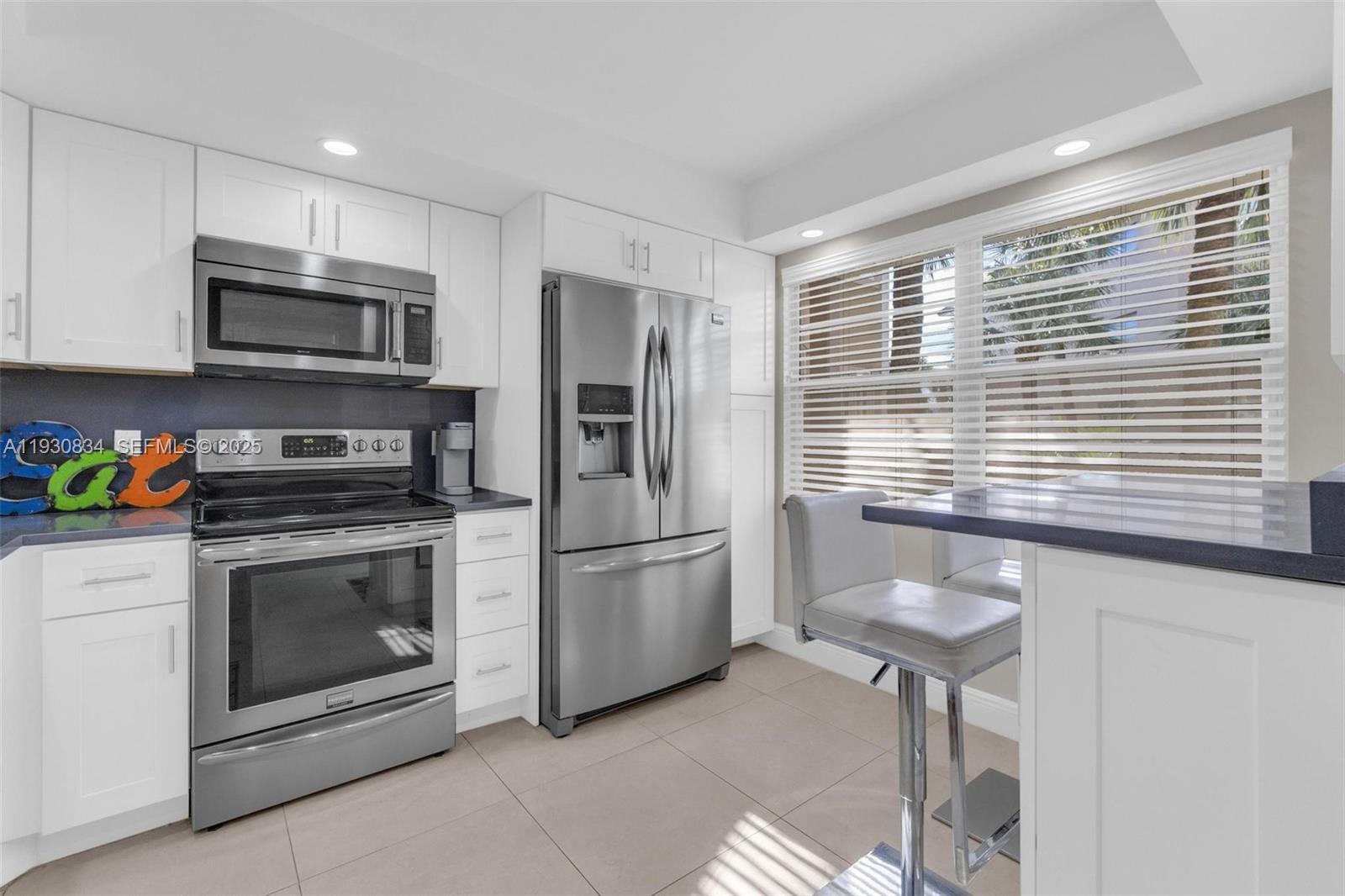 4402 Martinique Court, Unit K2 Coconut Creek, FL 33066 - Photo 6 of 38 a kitchen with stainless steel appliances granite countertop a stove a microwave and a refrigerator