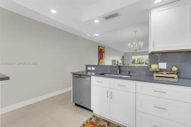 a kitchen with stainless steel appliances granite countertop a sink and a white cabinets