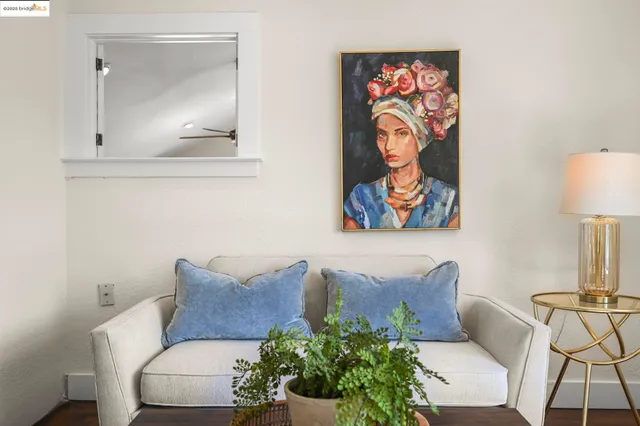 a living room with furniture and a painting on the wall