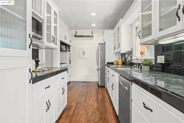 a kitchen with stainless steel appliances granite countertop a lot of counter space and wooden floors
