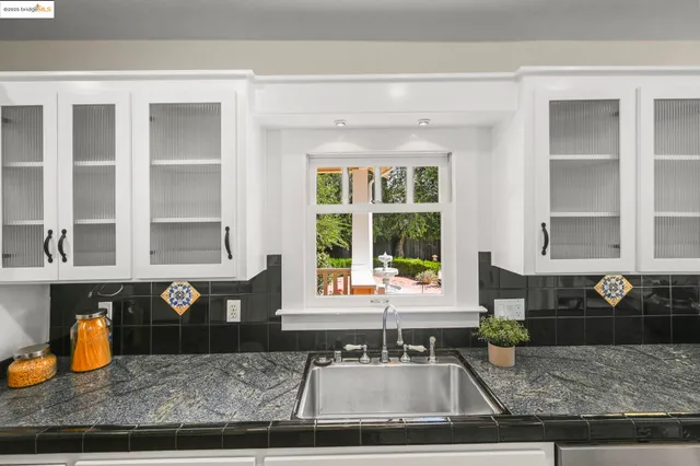 a view of a kitchen with granite countertop a sink and a window