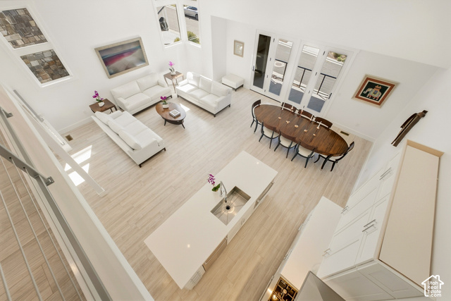 369 East Overlook Loop Kamas, UT 84036 - Photo 12 of 64 Open-concept living area with high ceilings, wood-finish flooring, a kitchen island with an integrated sink, and an expansive set of French doors