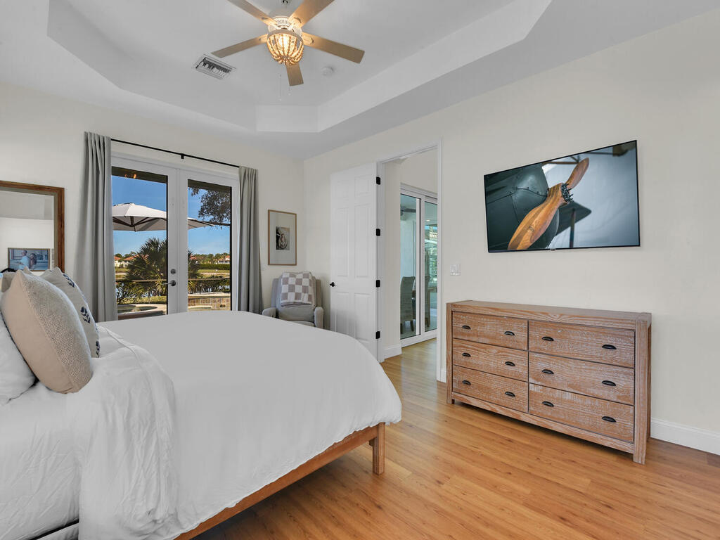 7851 Founders Circle Naples, FL 34104 - Photo 16 of 43 a bedroom with a bed a dresser and a large window