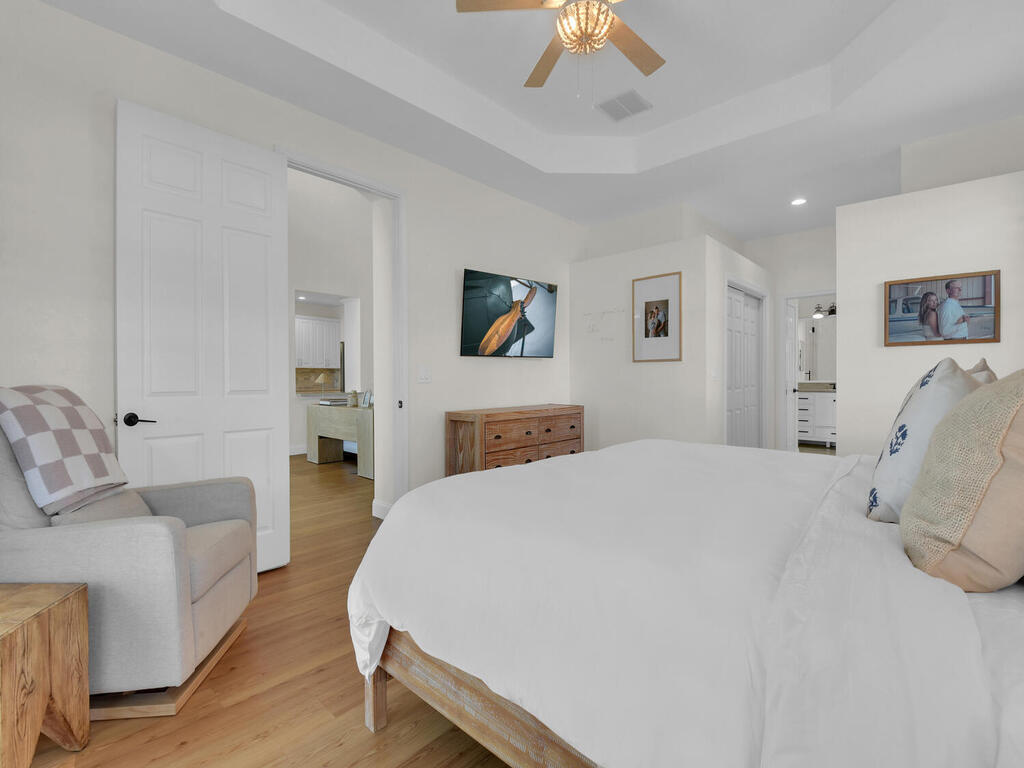 7851 Founders Circle Naples, FL 34104 - Photo 18 of 43 a spacious bedroom with a bed and a chandelier