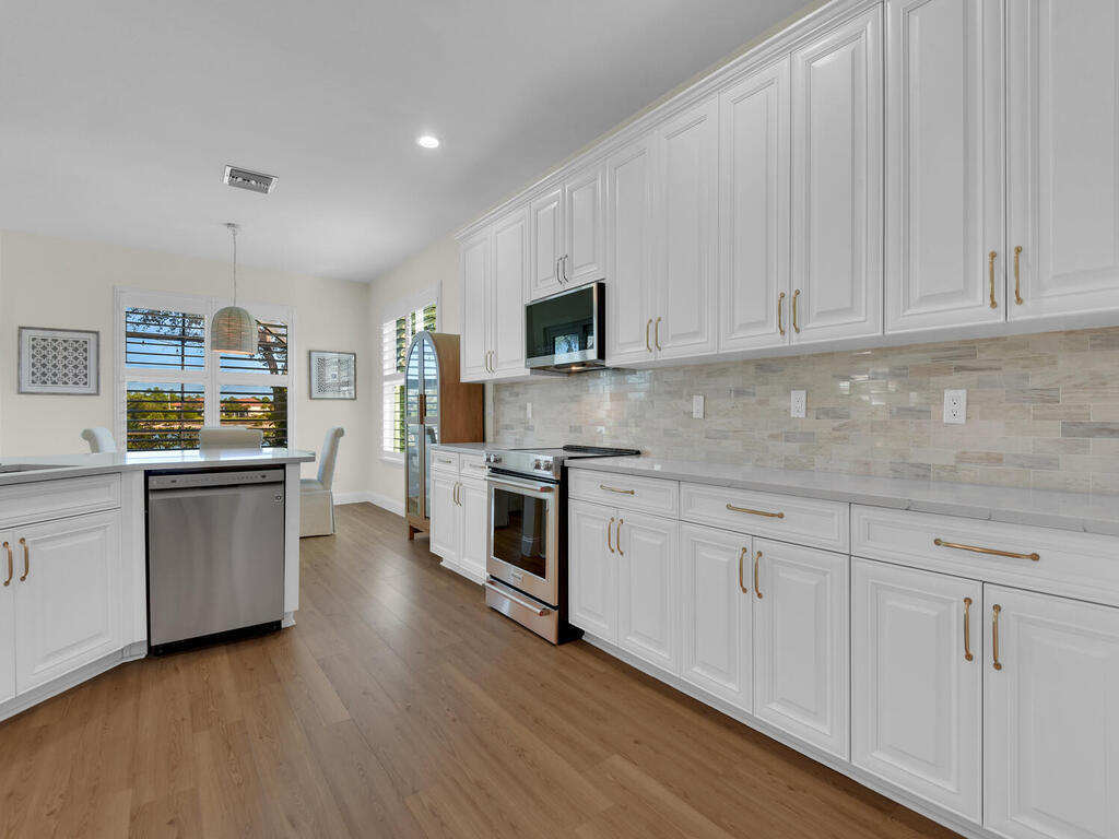 7851 Founders Circle Naples, FL 34104 - Photo 7 of 43 a kitchen with granite countertop white cabinets and white appliances