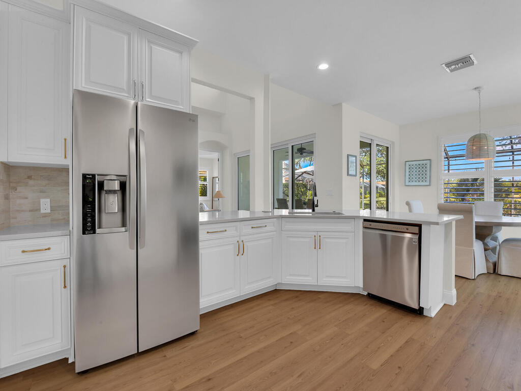 7851 Founders Circle Naples, FL 34104 - Photo 8 of 43 a kitchen with white cabinets and stainless steel appliances