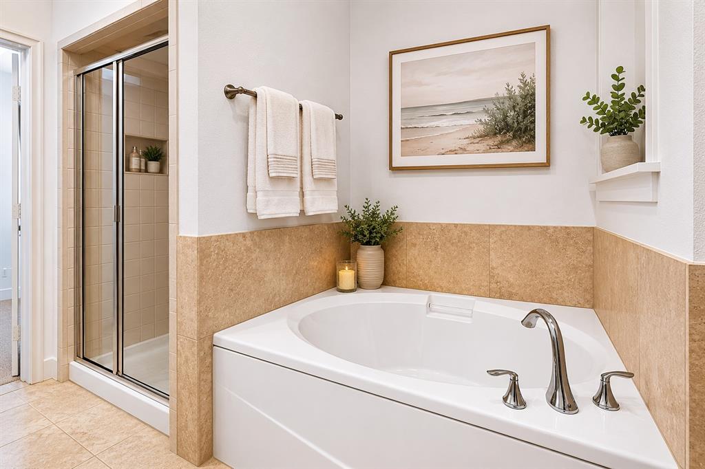 4211 Rawlins Street, Unit 528 Dallas, TX 75219 - Photo 9 of 14 White drop-in soaking tub with chrome fixtures, complemented by a tiled surround