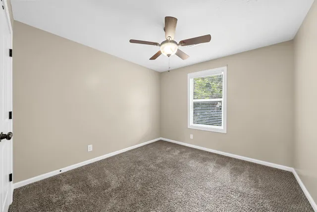 an empty room with closet and ceiling fan