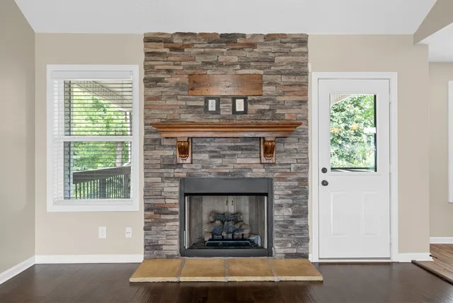 a living room with a fireplace and windows