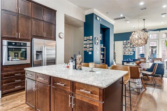 a kitchen with a stove a kitchen island a dining table and chairs