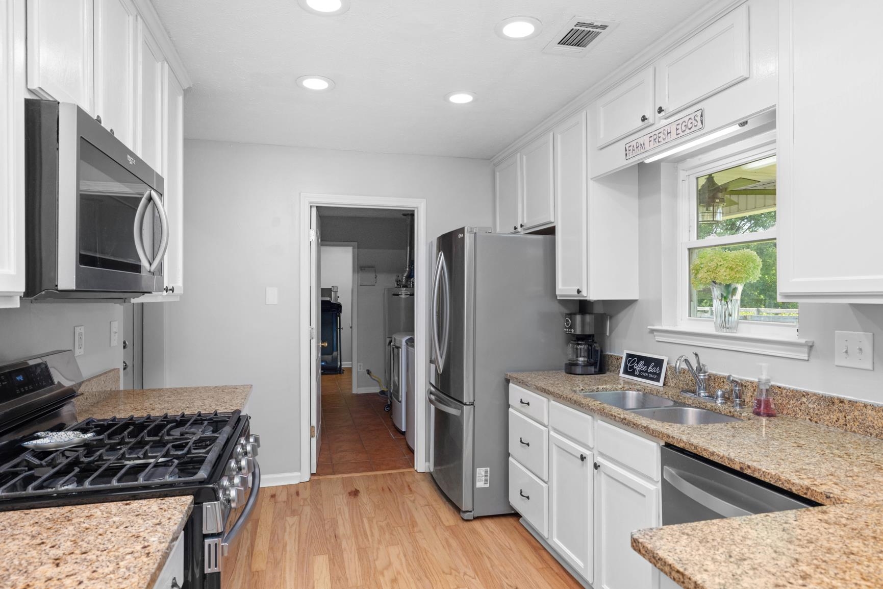 2640 Brighton-Clopton Road Brighton, TN 38011 - Photo 14 of 36 Kitchen with stainless steel appliances, white cabinetry, recessed lighting, light wood-type flooring, and light stone counters