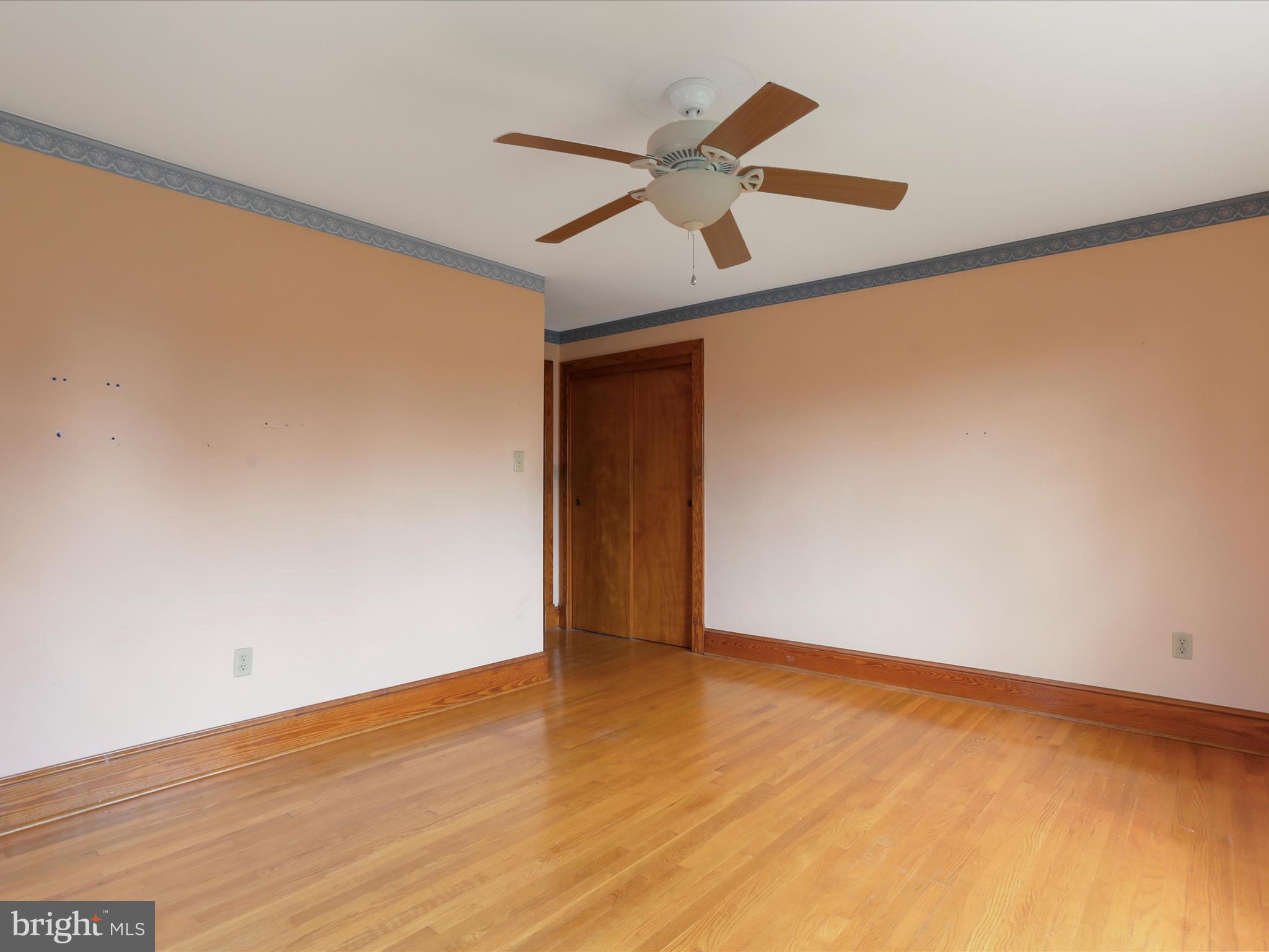 211 Broad Street Middletown, MD 21769 - Photo 12 of 35 an empty room with wooden floor and a ceiling fan