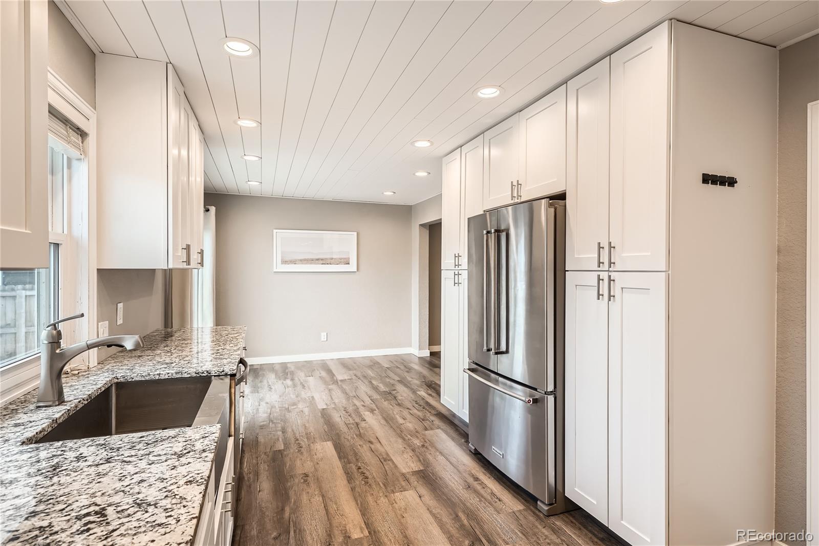 13158 West 62nd Drive Arvada, CO 80004 - Photo 14 of 35 a kitchen with stainless steel appliances granite countertop a refrigerator and a sink