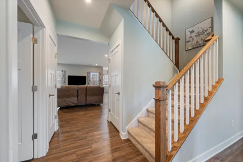 a kitchen with granite countertop a table chairs stainless steel appliances and wooden floor