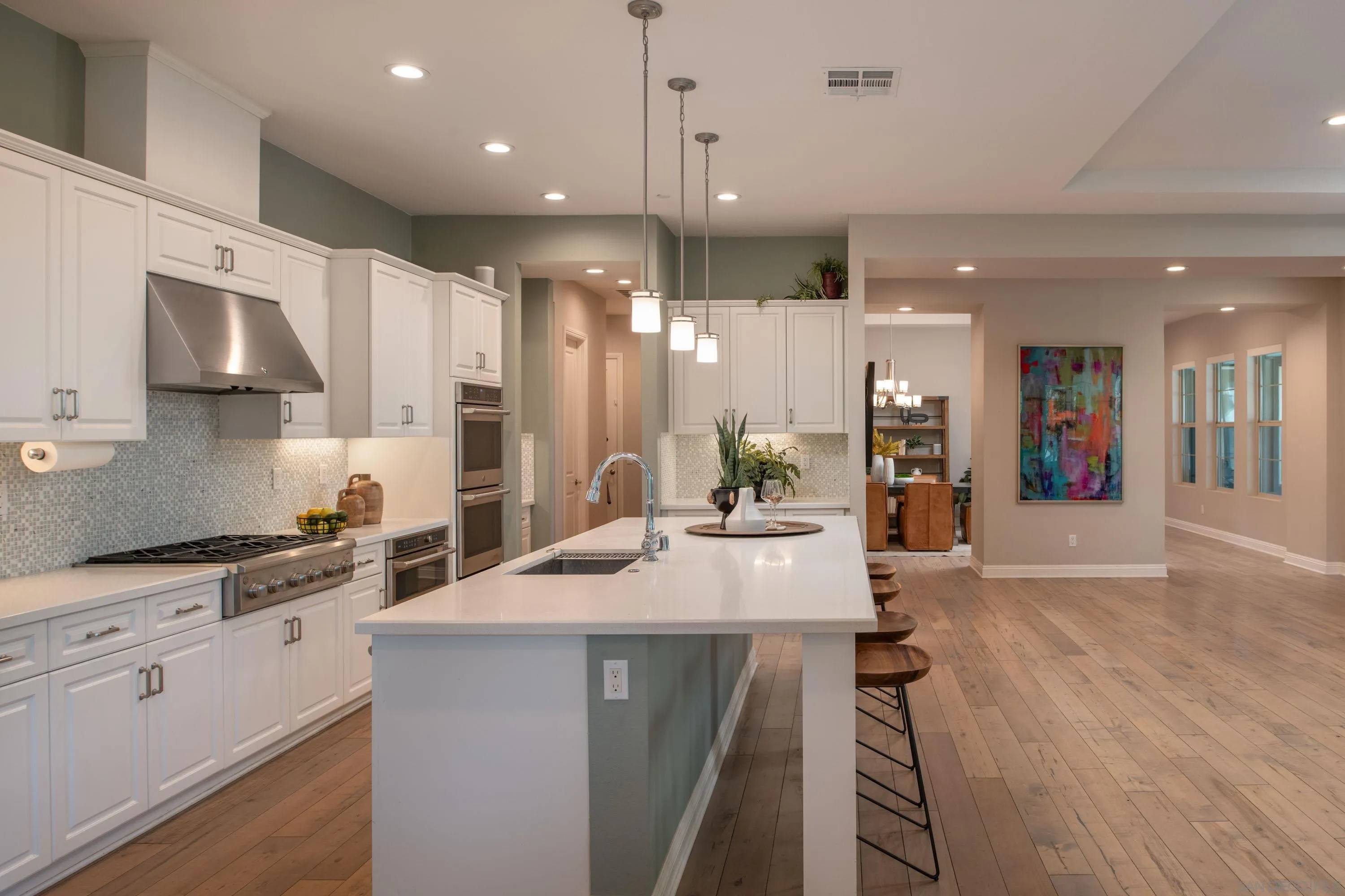 14516 Highcrest Court Poway, CA 92064 - Photo 16 of 71 a kitchen with stainless steel appliances kitchen island granite countertop a refrigerator a sink a stove and white cabinets with wooden floor