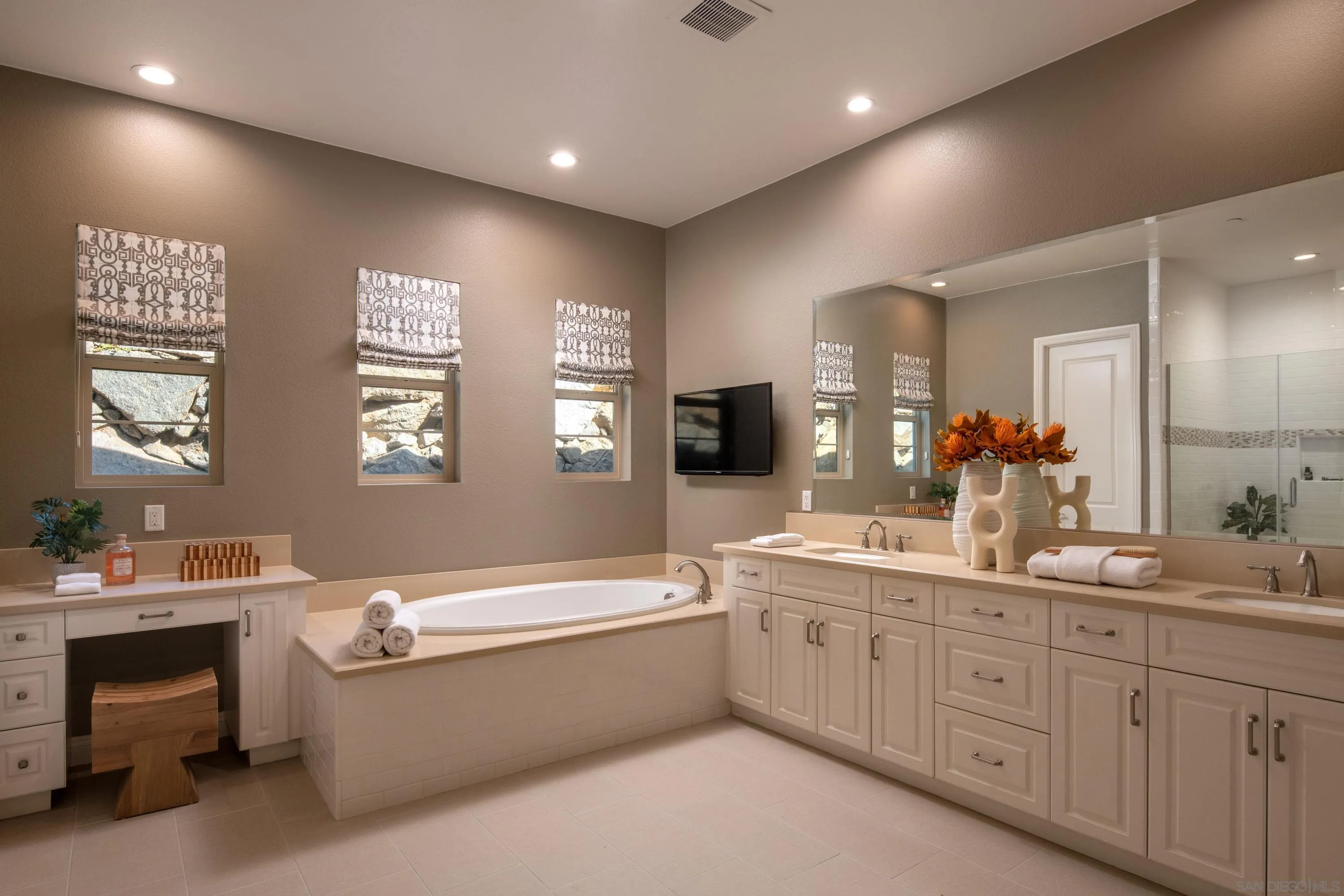 14516 Highcrest Court Poway, CA 92064 - Photo 30 of 71 a bathroom with a double vanity sink a large mirror and a bathtub
