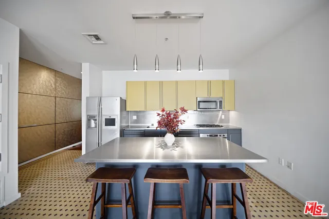 a kitchen with stainless steel appliances granite countertop a sink a stove and refrigerator