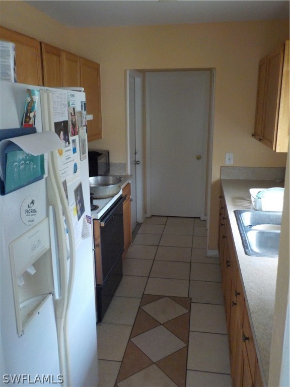 16981 First Street Alva, FL 33920 - Photo 4 of 12 a kitchen with stainless steel appliances a refrigerator a sink a stove top oven a washer and dryer