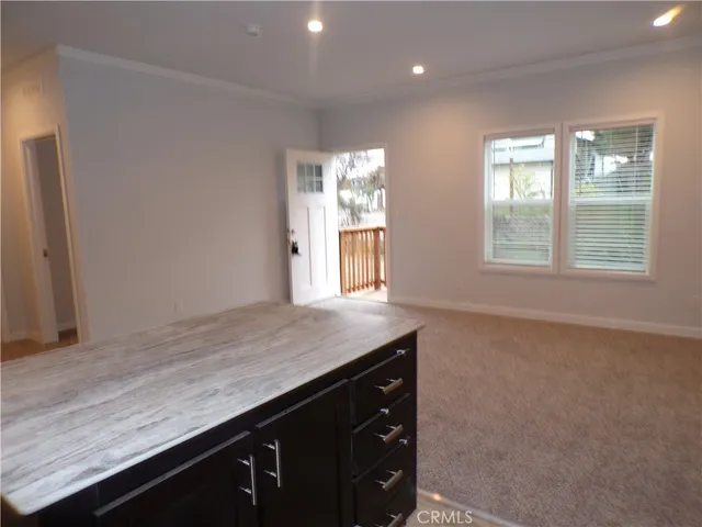 a kitchen with a refrigerator and wooden floor