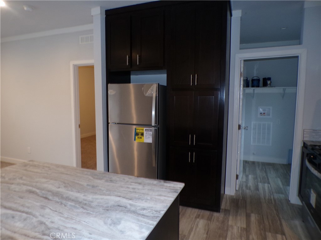 13586 Fair Oak Road Clearlake, CA 95422 - Photo 9 of 15 a kitchen with a refrigerator and wooden floor