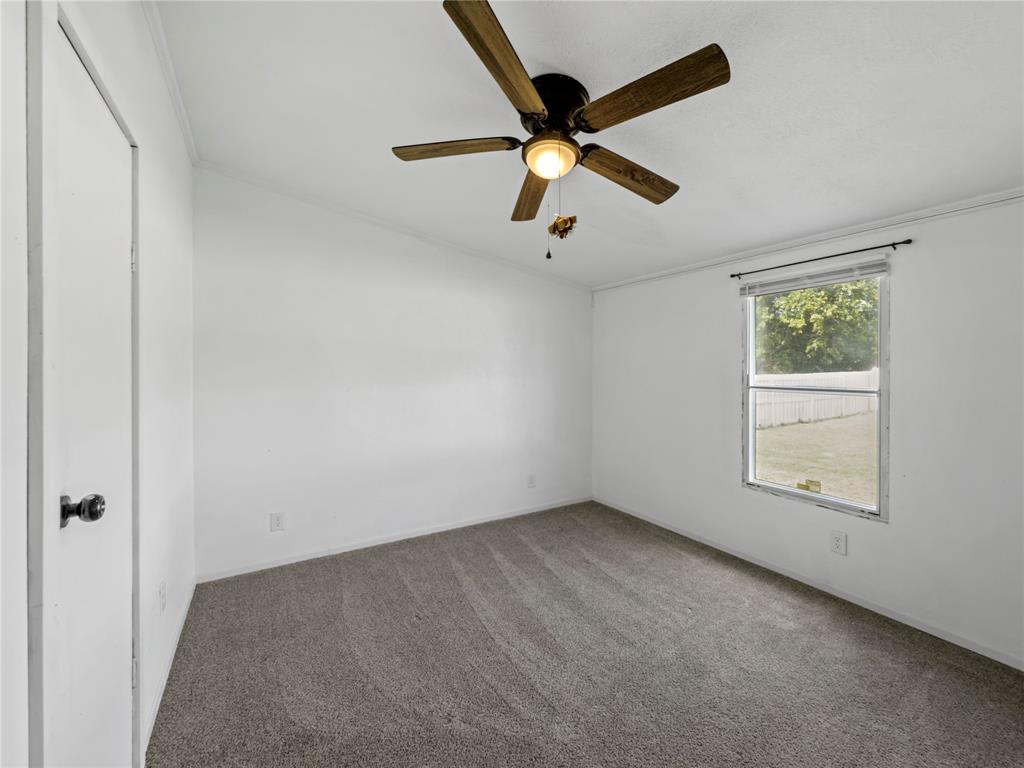 401 Barker Street Bowie, TX 76230 - Photo 17 of 24 an empty room with a window and a fan